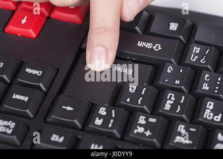 Finger drückt enter-Taste auf der Tastatur des Computers Stockfoto