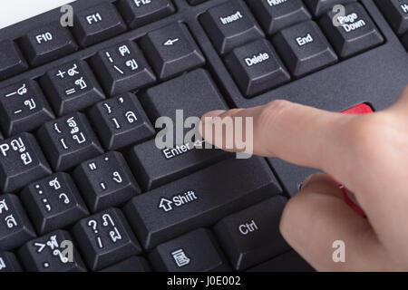 Finger drückt enter-Taste auf der Tastatur des Computers Stockfoto