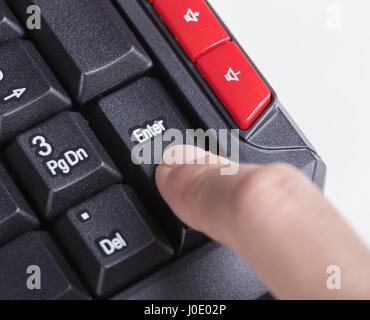 Finger drückt enter-Taste auf der Tastatur des Computers Stockfoto