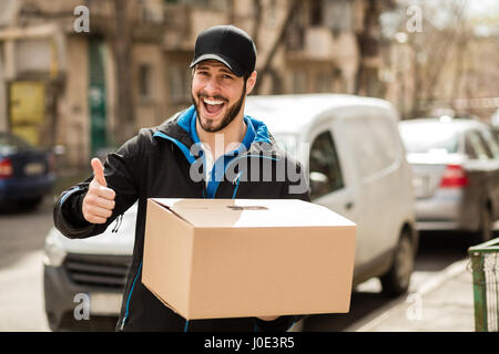 Lieferung Mann mit Mütze und Karton in Händen, so dass ok Sign. Stockfoto