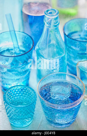 Blauen Trinkflaschen und Glas draußen im Regen Stockfoto