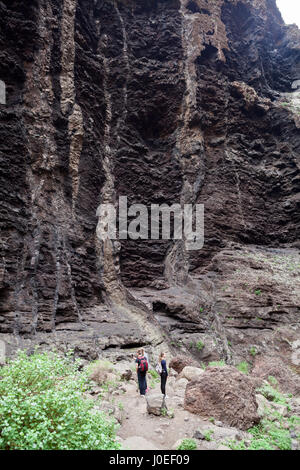 MASCA, Teneriffa, Spanien - ca. Januar 2016: Junge Wanderer-Team geht auf die Wanderroute durch die Masca-Schlucht. Masca-Schlucht ist ein beliebtes plac Stockfoto