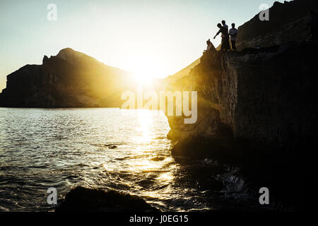 Omanische Männer sind bei Sonnenuntergang in Salalah, Oman Angeln. Stockfoto