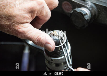 Bruce Russell, einen hochqualifizierten Gold & Silberschmied Einstellung ein Diamant in einem 18 Karat gold Ring an seiner Werkbank bei Le Gron in St. Saviours in Guernsey Stockfoto