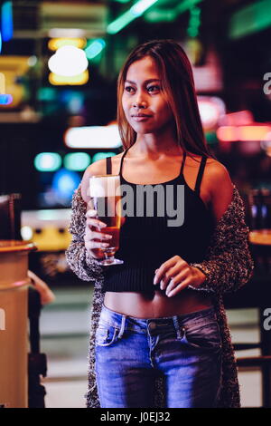 Junge schöne Frau trinkt Bier in einer bar Stockfoto
