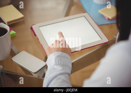 Nahaufnahme von Frau mit Tablet am Tisch im Haus Stockfoto