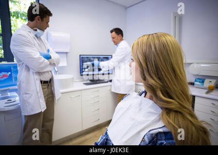 Zahnarzt Zähne Röntgen mit seinem Kollegen und Patienten in der Klinik zu diskutieren Stockfoto