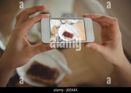 Beschnitten, Bild Frau mit Smartphone beim fotografieren Essen am Tisch Stockfoto