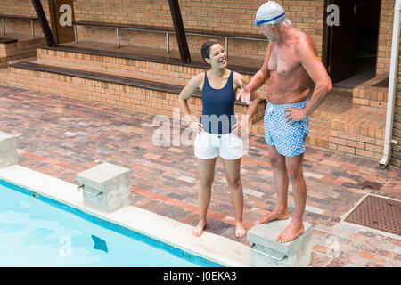Schwimmen Sie Trainer, die Interaktion mit älteren Mann am Pool Stockfoto