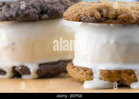 Ice Cream läuft aus Cookie Sandwiches, wie sie auf Tischplatte schmelzen Stockfoto