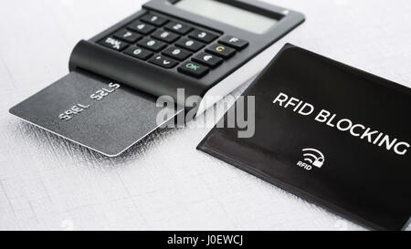 Schwarze Farbe RFID-Schutzhülse für sichere Kreditkarte aus vor hacking und TAN-Generator mit Credit Karte drin am Mittelweg Stockfoto