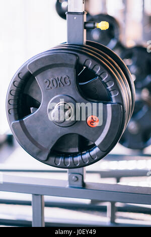 Satz von Metall Hanteln Datenträgern auf Barbbell Halter im Fitness-Studio Stockfoto