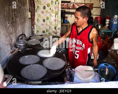 ANGONO, RIZAL, Philippinen - 21. Dezember 2016: Ein Mann macht Frühlingsrolle Wrapper in seinem Geschäft auf einem Markt. Stockfoto