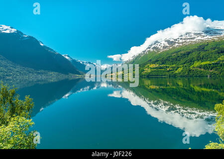 Schöne Reflexionen von schneebedeckten Bergen in einem vollkommen still, blau Norwegische See Stockfoto