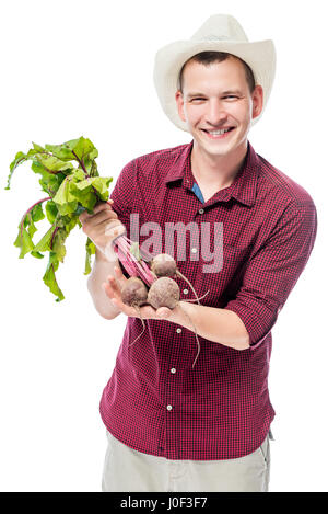 Glückliche Bauer zeigt eine Ernte von Zuckerrüben auf weißem Hintergrund Stockfoto
