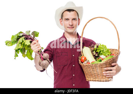 Junger Mann mit einem Korb mit Gemüse aus dem Garten auf einem weißen Hintergrund Stockfoto