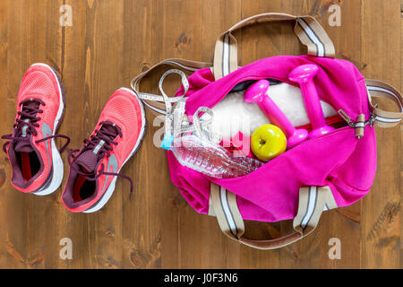 Öffnen Sie, Sporttasche und rosa Laufschuhe auf einen Holzboden-Draufsicht Stockfoto