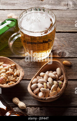 Lager-Bierkrug und Snacks auf Holztisch Stockfoto