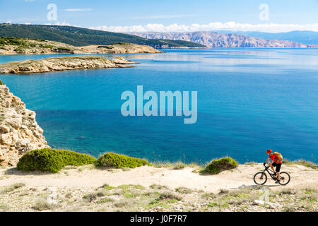 Mountainbiker am Fahrrad im Sommer oder Herbst inspirierend Berge Landschaft reiten. Mann Radsport MTB Enduro trail Strecke am Meer und felsigen Schmutz p Stockfoto