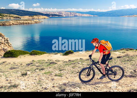 Mountainbiker am Fahrrad im Sommer inspirierende Berge und Meer Landschaft reiten. Mann Radsport MTB auf der Enduro Trail Strecke am Meer und felsigen Schmutz pat Stockfoto