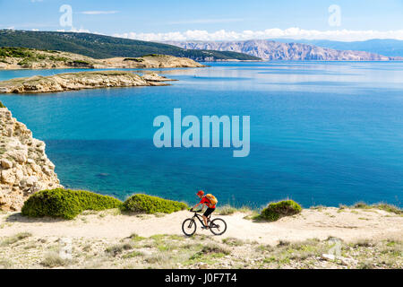 Mountainbiker am Fahrrad im Sommer oder Herbst inspirierend Berge Landschaft reiten. Mann Radsport MTB Enduro trail Strecke am Meer und felsigen Schmutz p Stockfoto