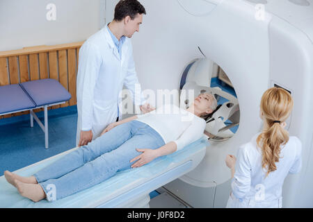 MRT-Untersuchung. Angenehm gut aussehenden männlichen Arzt Stand in der Nähe seines Patienten und ärztliche Untersuchung mit MRT zu tun Stockfoto