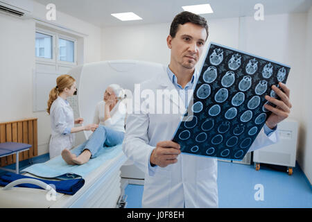 Sicher angenehmer Arzt arbeitet mit MRI-Scan-Ergebnisse Stockfoto