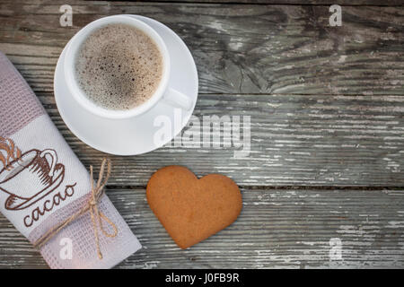 Tasse Kaffee mit Ingwer-Plätzchen auf Holztisch. Herzform Lebkuchen. Kaffeepause, Frühstück. Stockfoto