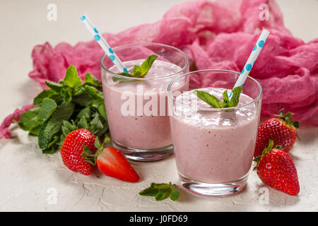 Erdbeer-Banane Smoothie oder Milchshake in zwei Gläser auf hellem Hintergrund Stockfoto