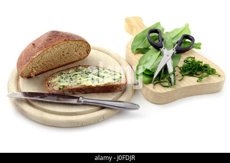 frisches Schwarzbrot und Bärlauch-Butter mit Kräuter Schere und frischen Bärlauch-Blätter auf isolierte Hintergrund Stockfoto