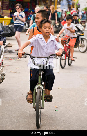 Vertikale Porträt des jungen auf Fahrrädern durch die Straßen in Hoi an, Vietnam. Stockfoto