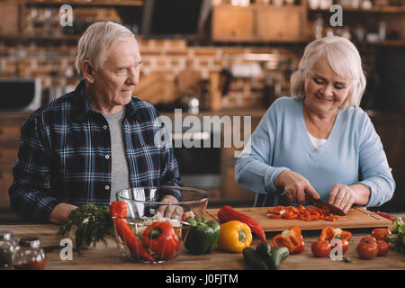 Porträt des Lächelns älteres paar machen Salat zusammen in Küche Stockfoto