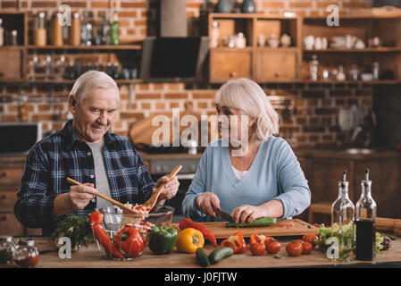 Porträt des Lächelns älteres paar machen Salat zusammen in Küche Stockfoto