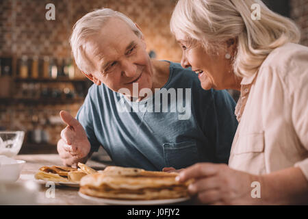 älteres paar essen Pfannkuchen in der Küche zu Hause Stockfoto