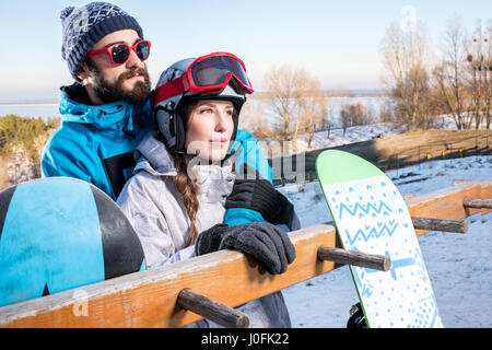 Jungen männlichen und weiblichen Snowboarder umarmen und mit Blick auf Distanz Stockfoto