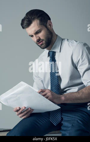 Porträt des Kaufmanns am Tisch sitzen und Lesen von Dokumenten Stockfoto