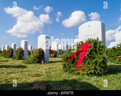 Reihen von Grabsteinen mit Kränzen & roten Bögen in Sarasota National Cemetery in Sarasota Florida Stockfoto