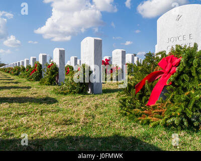 Reihen von Grabsteinen mit Kränzen & roten Bögen in Sarasota National Cemetery in Sarasota Florida Stockfoto