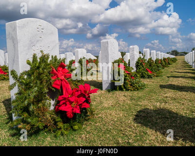 Reihen von Grabsteinen mit Kränzen & roten Bögen in Sarasota National Cemetery in Sarasota Florida Stockfoto