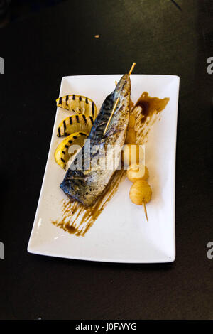 Makrele gegrillt. Makrele mit Zitrone auf einem weißen Teller. Stockfoto