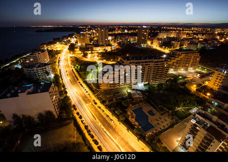 Stadt am Ufer des Ozeans mit Gebäuden und Hotels während des Sonnenuntergangs. Ansicht von oben. Portimao, Algarve, Portugal. Stockfoto