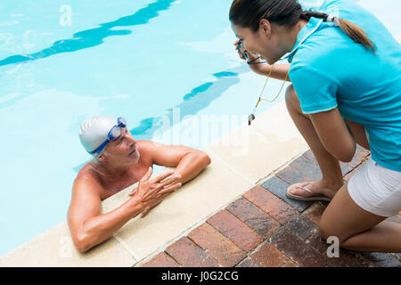 Trainer mit Stoppuhr, senior Mann am Pool Stockfoto