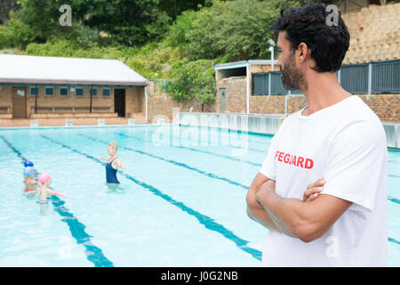 Rettungsschwimmer Blick auf Studenten an einem sonnigen Tag im Pool Spielen Stockfoto