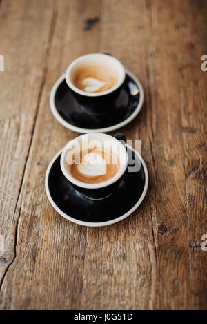 Zwei Tassen Kaffee auf hölzernen Hintergrund Stockfoto