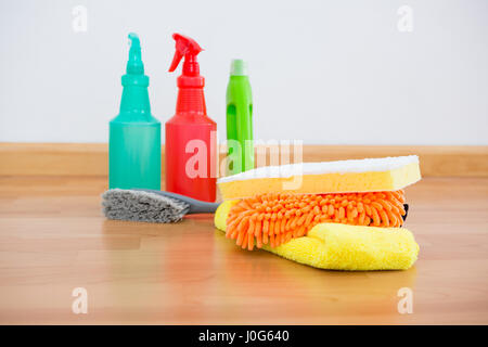 Reinigung von Schwamm und chemische Flaschen auf Hardwoodfloor hautnah Stockfoto