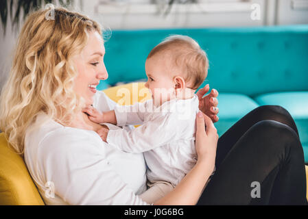 Mutter und Kind am gelben Sessel sitzen und Lächeln Stockfoto