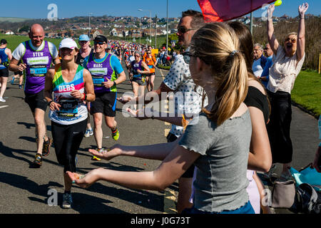 Menschen vor Ort bieten Süßigkeiten an die Athleten die Teilnahme In Brighton Marathon, Brighton, Sussex, Großbritannien Stockfoto