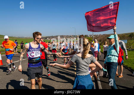 Menschen vor Ort bieten Süßigkeiten an die Athleten die Teilnahme In Brighton Marathon, Brighton, Sussex, Großbritannien Stockfoto