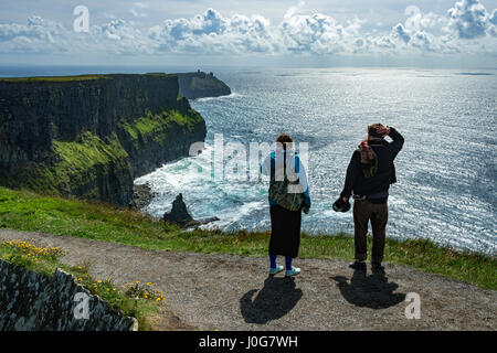 Zwei Wanderer auf dem Klippenpfad an den Cliffs of Moher, mit Blick nach Südwesten in Richtung Hags Head, County Clare, Irland Stockfoto