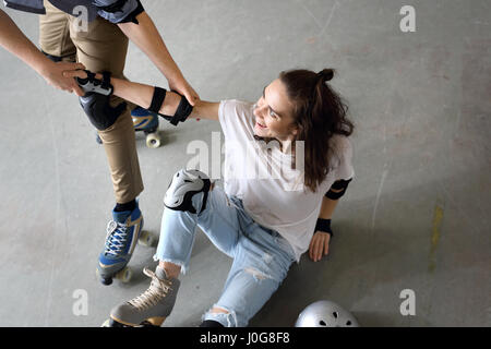 Inline-Skates. Frau auf Rollschuhen. Rollerskating Helm, Kopfschutz. Junge Leute Reiten auf Rollschuhen-Pads und Knieschoner Stockfoto